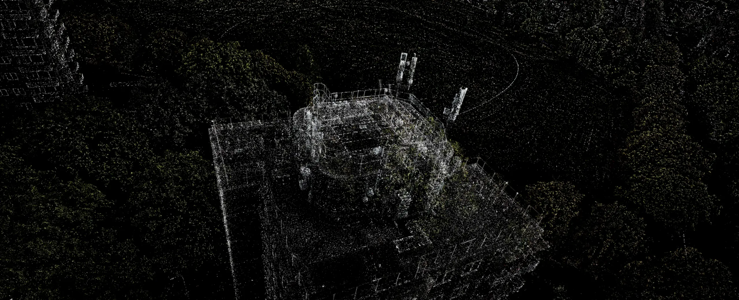 Black and white 3D point cloud scan of a building structure surrounded by trees